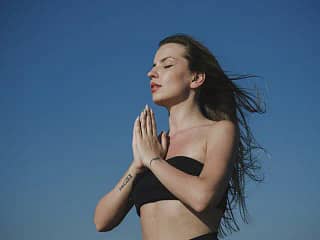 Woman meditating with hair blowing in the wind. Abundance Affirmations