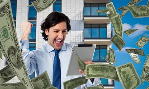 Man reading a tablet looking very happy with money raining down on him