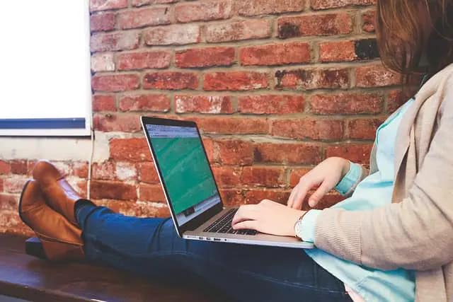 Person with feet kicked up and legs crossed on laptop working. Engaging Content